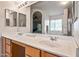 Double vanity bathroom with large mirror and bright lighting at 6751 N 77Th Dr, Glendale, AZ 85303