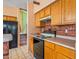 Kitchen with wood cabinets, black appliances, and a view of the staircase at 6751 N 77Th Dr, Glendale, AZ 85303