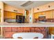 Kitchen with breakfast bar, wood cabinets and a view into another room at 6751 N 77Th Dr, Glendale, AZ 85303