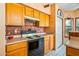 Kitchen with wood cabinets, copper backsplash, and electric range at 6751 N 77Th Dr, Glendale, AZ 85303