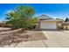 Single story home with a large tree and gravel driveway at 6810 W Vermont Ave, Glendale, AZ 85303