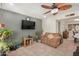 Living room with tiled floor, brown couch, and large TV at 6810 W Vermont Ave, Glendale, AZ 85303