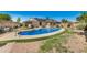 Blue kidney shaped pool with surrounding grass at 6810 W Vermont Ave, Glendale, AZ 85303