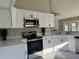 Modern kitchen with white cabinets, stainless steel appliances, and quartz countertops at 7045 W Ocotillo Rd, Glendale, AZ 85303