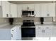 Modern kitchen with white cabinets, stainless steel appliances, and quartz countertops at 7045 W Ocotillo Rd, Glendale, AZ 85303