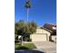 Tan stucco home with a two-car garage and mature landscaping at 7904 E Pepper Tree Ln, Scottsdale, AZ 85250