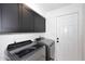 Well-equipped laundry room featuring modern washer and dryer, and dark cabinetry at 7904 E Pepper Tree Ln, Scottsdale, AZ 85250