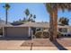 White single story home with a brown garage door and mature landscaping at 8119 E San Miguel Ave, Scottsdale, AZ 85250