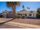 Front view of a white single story home with a brown garage door, landscaping, and palm trees at 8119 E San Miguel Ave, Scottsdale, AZ 85250