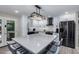 Updated kitchen featuring white shaker cabinets, expansive island, and stainless steel appliances at 8431 E Stella Ln, Scottsdale, AZ 85250