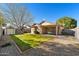 A fully landscaped backyard with gravel, grass, a covered patio and block wall at 8549 E Carol Ave, Mesa, AZ 85208