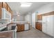 Functional kitchen featuring tile floors, white appliances, wood cabinets, and a casual dining area at 8549 E Carol Ave, Mesa, AZ 85208