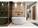 Bathroom with freestanding tub and stone wall feature at 9374 E Andora Hills Dr, Scottsdale, AZ 85262