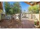 Landscaped backyard with a gated entrance and mature trees at 101 S Mesquite St, Wickenburg, AZ 85390