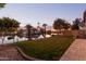 Scenic backyard view overlooking a lake with lush landscaping at sunset at 1501 W Blue Ridge Way, Chandler, AZ 85248