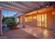 Evening view of a covered patio with pergola and string lights at 15583 W Big Sky Dr, Surprise, AZ 85374