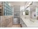 Bathroom with double vanity and a glass block shower at 15583 W Big Sky Dr, Surprise, AZ 85374