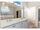 Bathroom with double vanity, glass block shower, and tile flooring at 15583 W Big Sky Dr, Surprise, AZ 85374