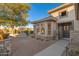 Home with inviting patio seating area and a gray front door at 15583 W Big Sky Dr, Surprise, AZ 85374