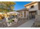 Home with inviting patio seating area and a gray front door at 15583 W Big Sky Dr, Surprise, AZ 85374