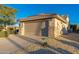Two-car garage with a tan stucco exterior and stone accents at 15583 W Big Sky Dr, Surprise, AZ 85374