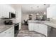 Modern kitchen with granite countertops, stainless steel appliances, and white cabinets at 15583 W Big Sky Dr, Surprise, AZ 85374