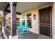 Covered porch with two teal chairs and a wrought iron door at 25320 N 52Nd Ave, Phoenix, AZ 85083