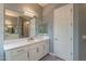 Bathroom vanity with white marble counter and cabinets, with large mirror and lights at 36925 N Stoneware Dr, Queen Creek, AZ 85140