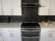 Modern kitchen with black and gold accents, geometric backsplash, and stainless steel appliances at 4016 W Wagon Wheel Dr, Phoenix, AZ 85051