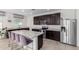 Modern kitchen featuring an island, stainless steel appliances, and dark wood cabinets at 8209 W Lane Ave, Glendale, AZ 85303