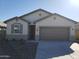 One-story house with light-colored siding, gray garage door, and a small front yard at 8283 W Mantle Way, Florence, AZ 85132