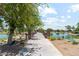 Walking path leading to a lake with natural rock landscaping and lush trees at 8283 W Mantle Way, Florence, AZ 85132