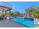Inviting pool with blue tile accents and wrought iron fence surrounded by mature desert landscaping at 9452 S 51St St, Phoenix, AZ 85044