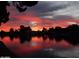 Beautiful sunset over a serene lake with tree silhouettes at 10642 W Mohawk Ln, Peoria, AZ 85382