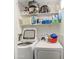 Laundry area with washer, dryer, and shelving for supplies at 11451 E Broadway Rd, Mesa, AZ 85208