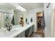 Elegant bathroom with dual sinks, large mirror, and walk-in closet at 11935 N 148Th Ave, Surprise, AZ 85379