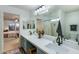 Bathroom with dual sinks, large mirror, and view into bedroom at 11935 N 148Th Ave, Surprise, AZ 85379