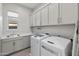 Bright laundry room with modern washer, dryer, and cabinets at 12007 W Creosote Dr, Peoria, AZ 85383