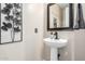 Elegant powder room with pedestal sink and decorative mirror at 13627 N 150Th Ave, Surprise, AZ 85379