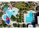 Aerial view of resort-style pools, a splash pad, and manicured landscaping at 1649 N Fenway Dr, Florence, AZ 85132