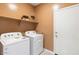 Laundry room with white washer and dryer, shelving and a white door at 1649 N Fenway Dr, Florence, AZ 85132