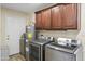 Bright laundry room with washer, dryer, cabinets, and water heater at 19320 W Melvin St, Buckeye, AZ 85326