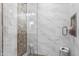 Spa-like shower with glass enclosure and pebble tile accent at 19320 W Melvin St, Buckeye, AZ 85326