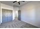 Bright bedroom with gray closet doors and ceiling fan at 205 E Jackson Ave, Buckeye, AZ 85326