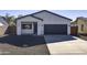 Newly built home with modern facade, driveway, and landscaped yard at 205 E Jackson Ave, Buckeye, AZ 85326