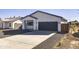 Modern craftsman style home with a dark garage door and wood fence at 205 E Jackson Ave, Buckeye, AZ 85326