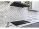 Modern kitchen with a black cooktop and white tile backsplash at 205 E Jackson Ave, Buckeye, AZ 85326