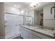 A modern bathroom features a glass-enclosed shower, double sink with granite countertops at 24636 W Hopi St, Buckeye, AZ 85326