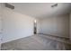 A spacious bedroom featuring neutral carpeting and paint, along with an ensuite bathroom at 24636 W Hopi St, Buckeye, AZ 85326