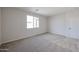 A bright bedroom with a window, neutral carpeting and paint at 24636 W Hopi St, Buckeye, AZ 85326